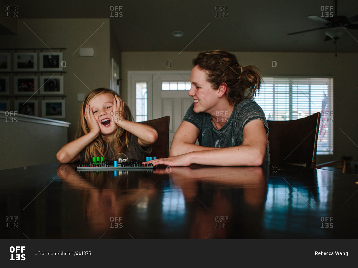 Boy reacting playing board game with mom