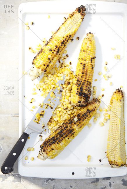 Grilled corn with kernels being removed