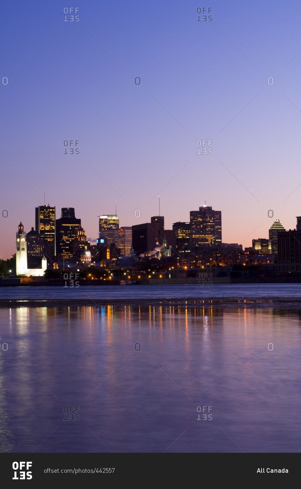 Evening view of skyline with old Montreal in foreground, across St. Lawrence River from Ile Notre-Dame, Montreal, Quebec, Canada.
