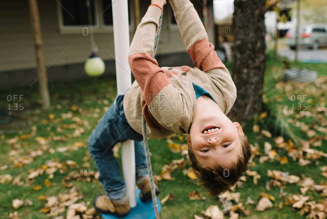 Boy playing on a play structure in his yard