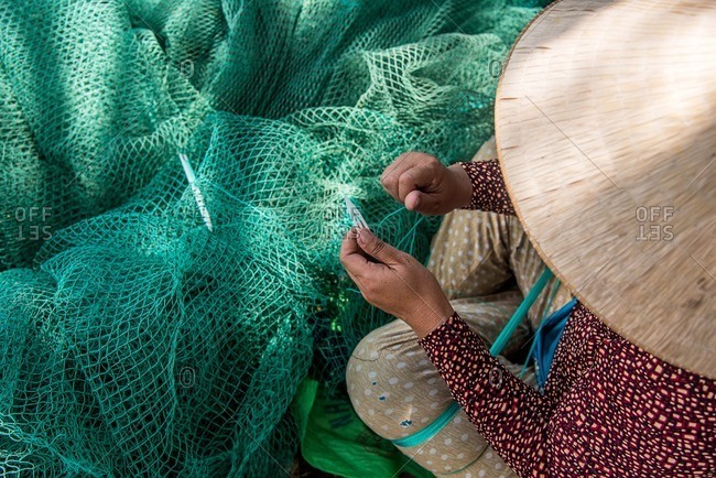 Vietnamese woman fixing fishing net