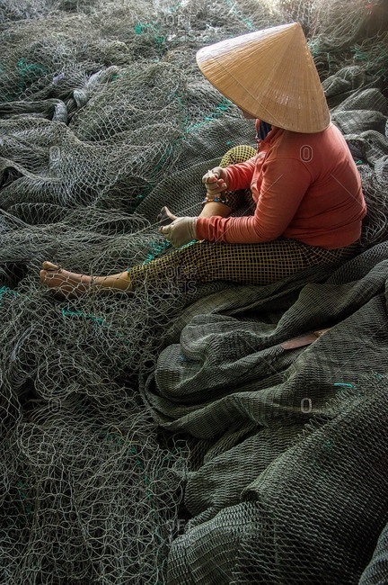Vietnamese woman working on fishing net