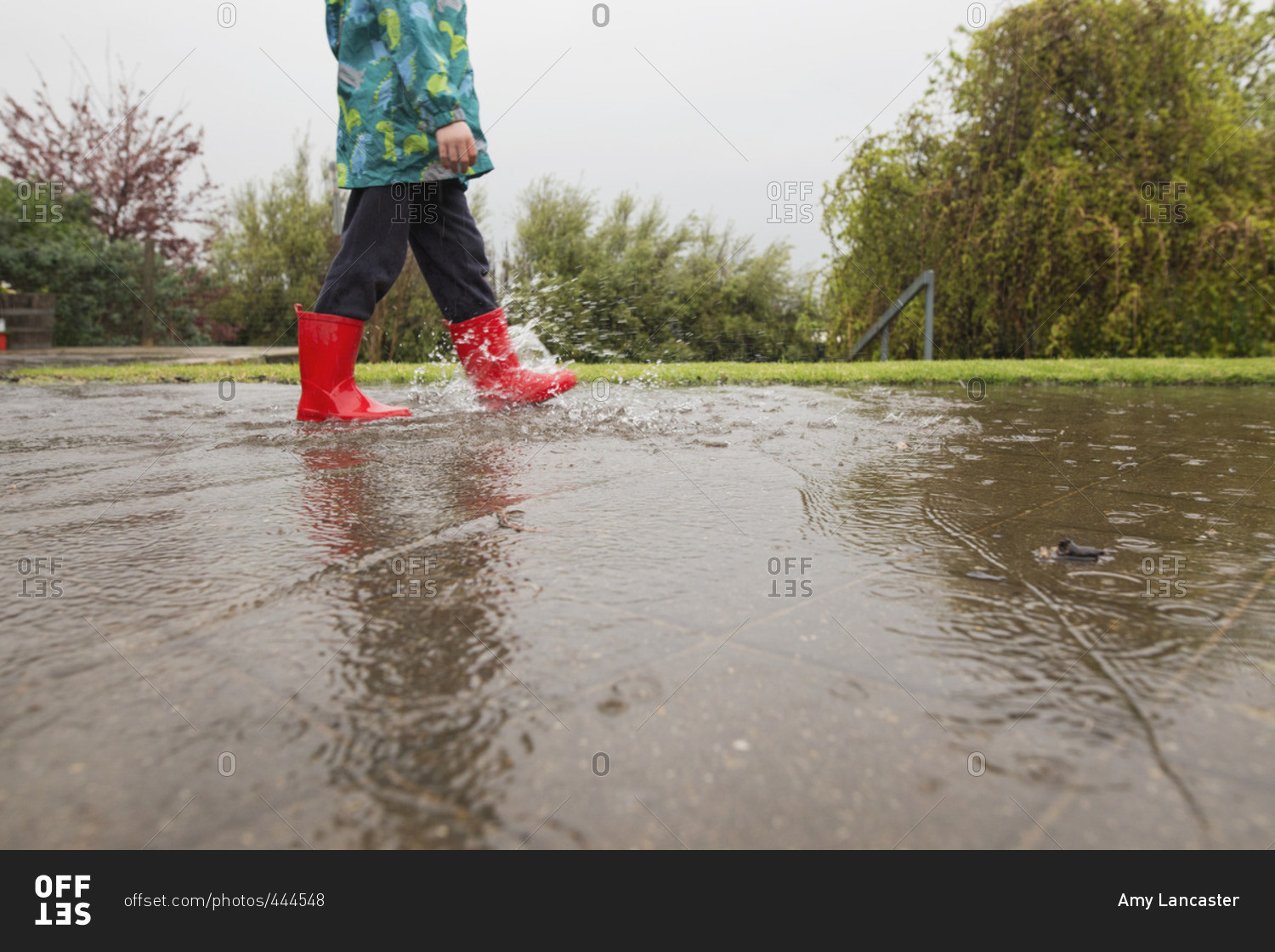 Child walking in rain water on ground