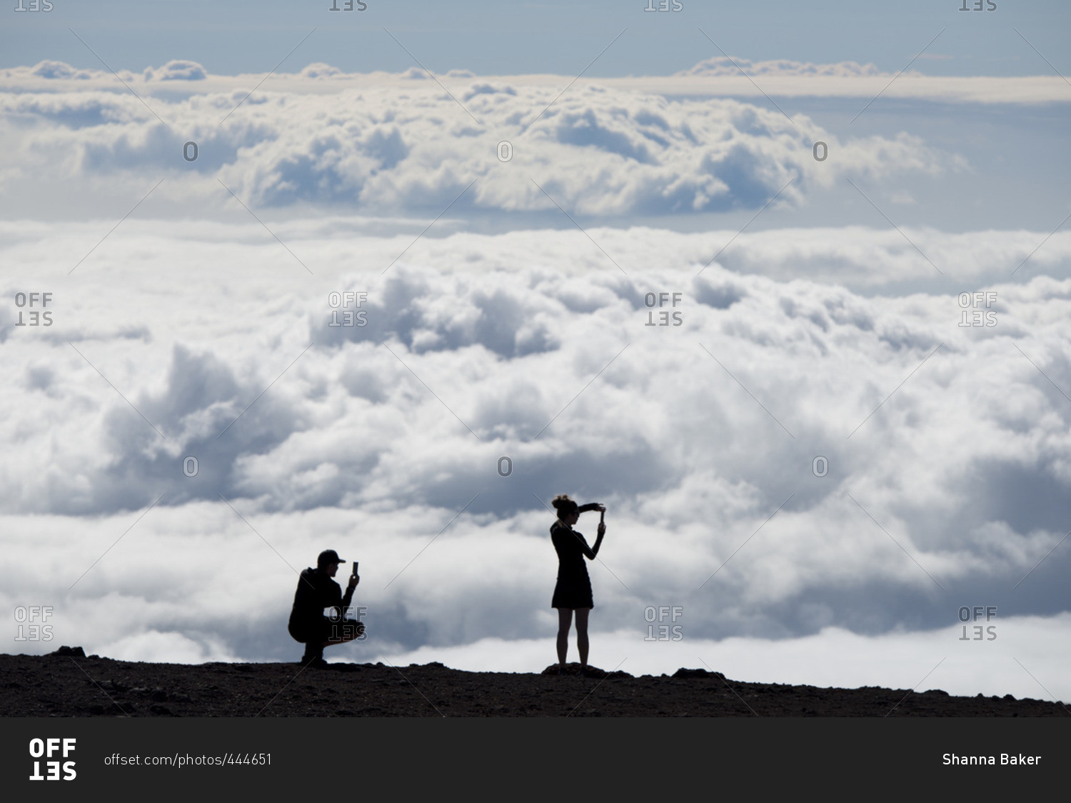 People silhouetted against the clouds at a lookout point in Haleakala National Park, Maui, Hawaii