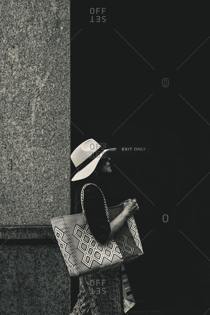 New York City, New York - February 22, 2016: Lady with a textured bag walking on Madison Avenue
