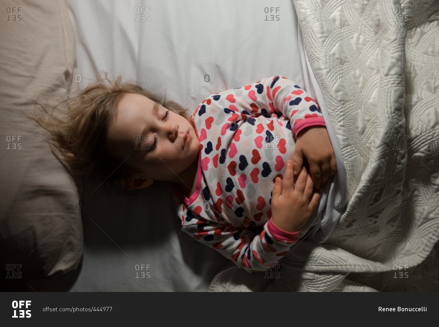 Little girl fast asleep wearing heart pajamas
