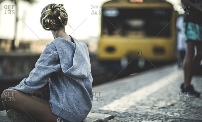 Woman sitting outside on a train platform