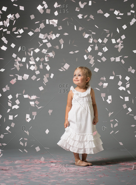 Girl standing among falling confetti