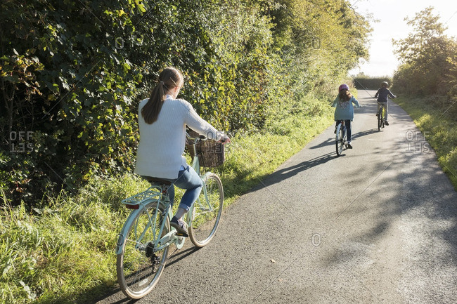 A family bike ride with mother and two children in the countryside.