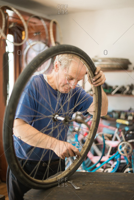 Man repairing bike tire in his shop