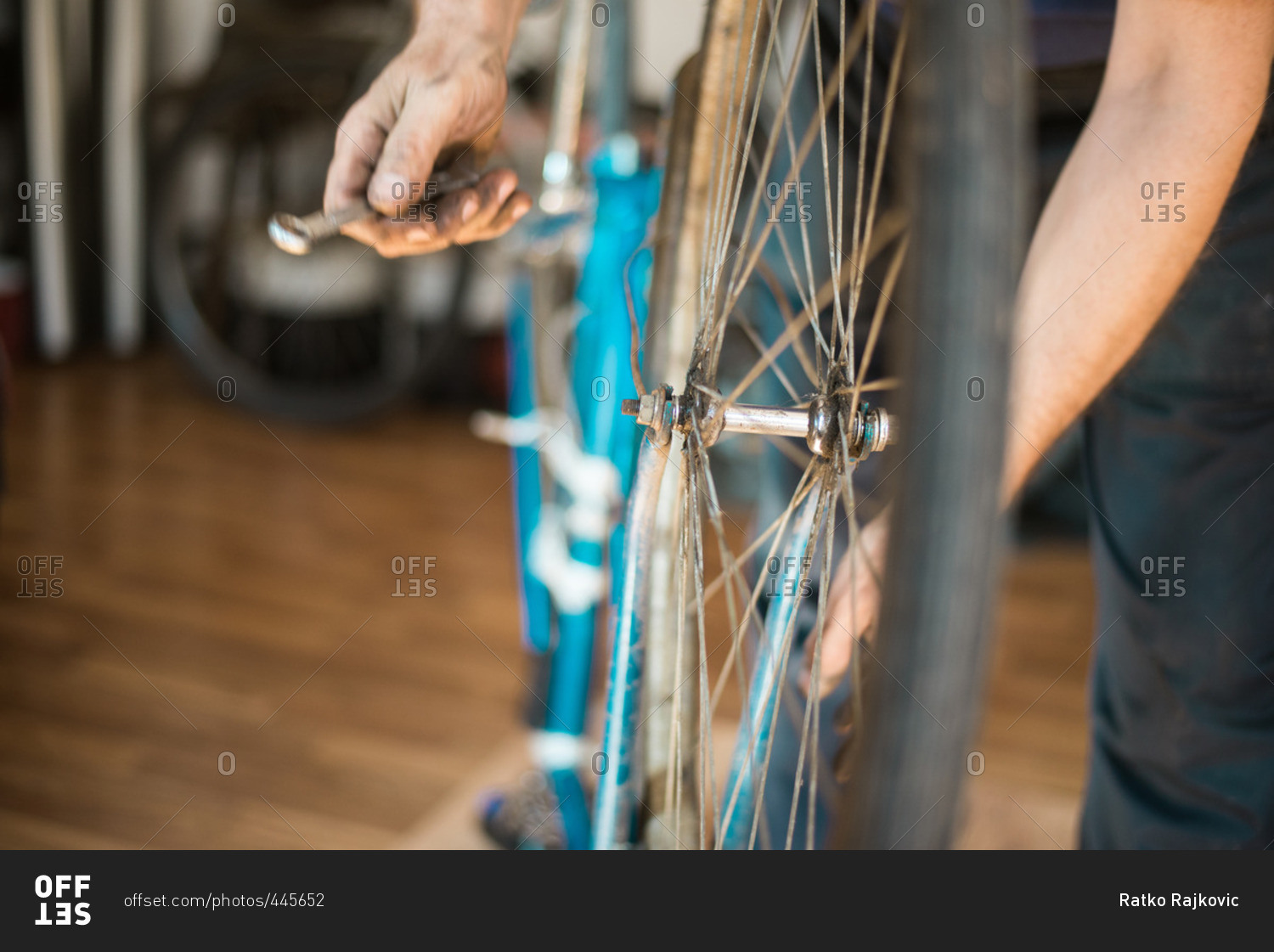 Man putting bike tire onto a bike frame in his workshop