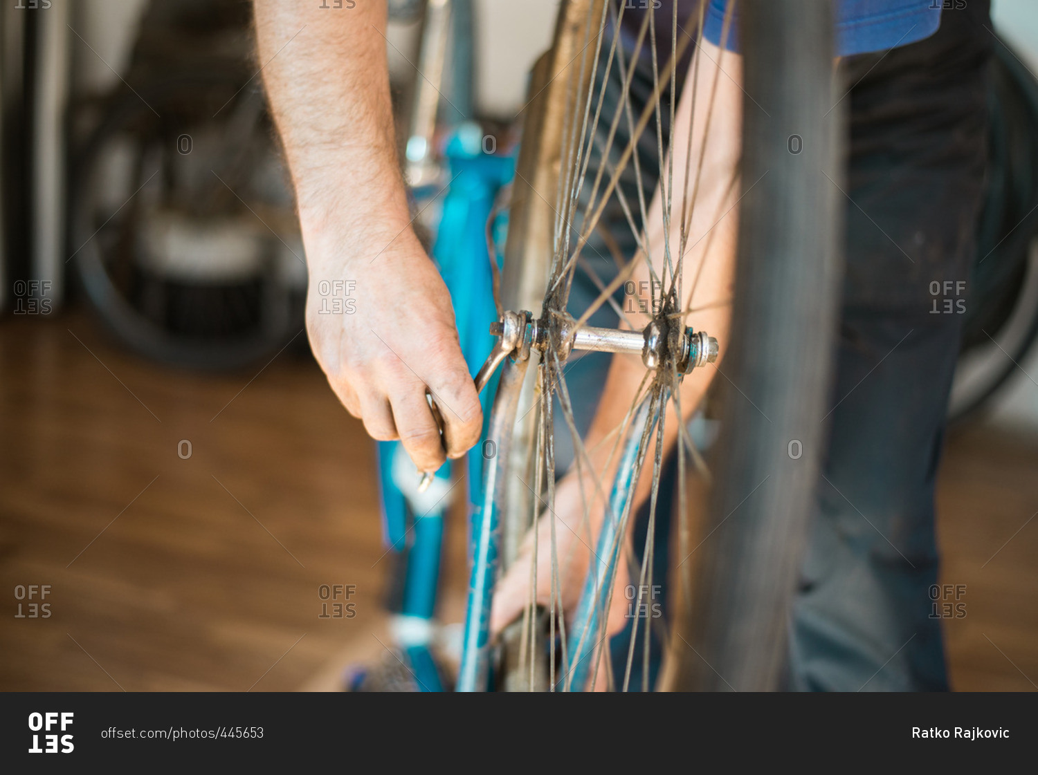 Man putting bike tire onto a bike frame and tightening the bolts