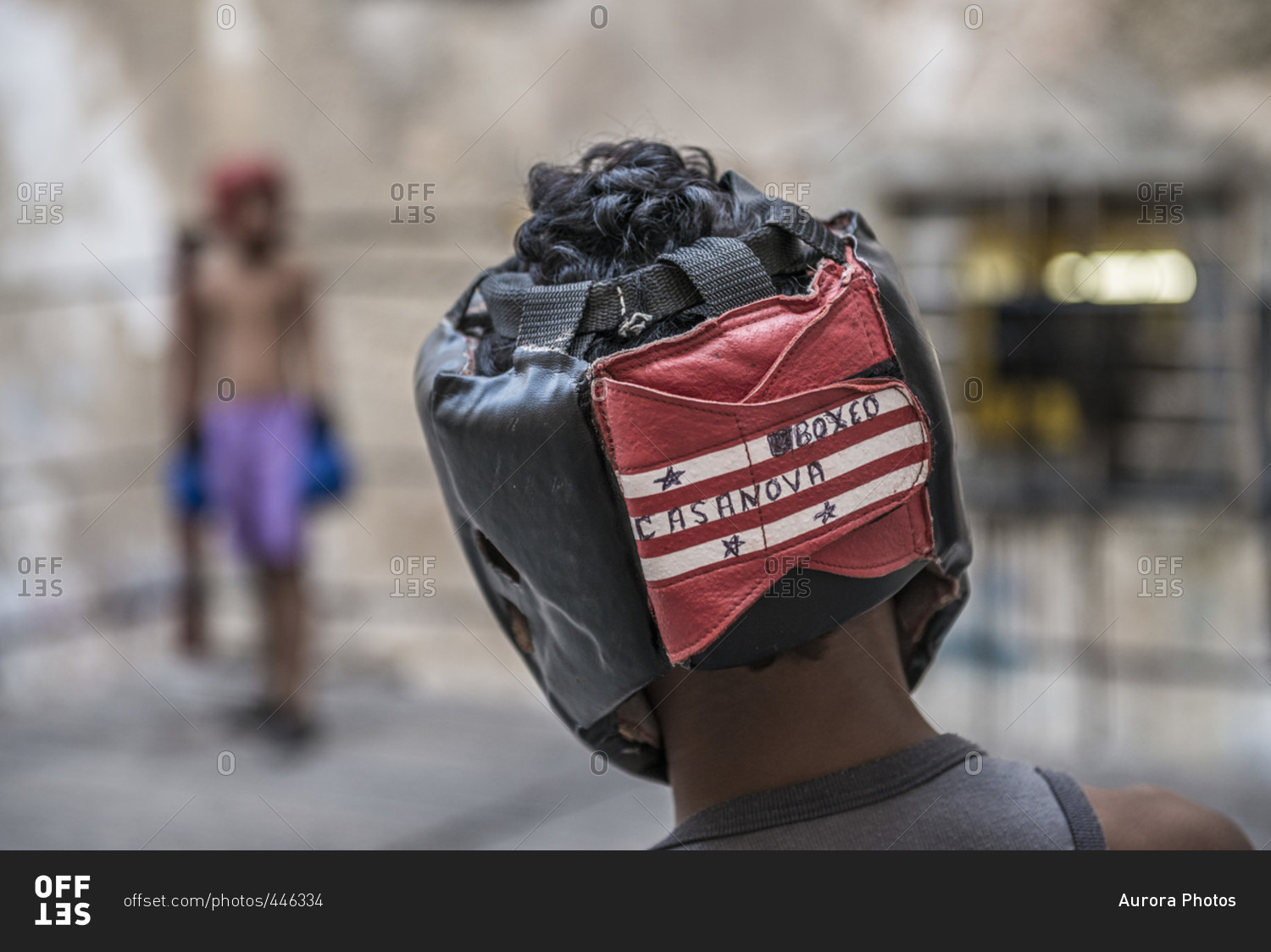 Old Havana, La Habana, Cuba - April 24, 2014: Close-up of a\
the head and headgear of a young Cuban boy as he prepares to spar\
with his opponent seen in the background at Project Cuba Boxeo, an\
aid project from Malaika Aid for Children, the creation of Sam