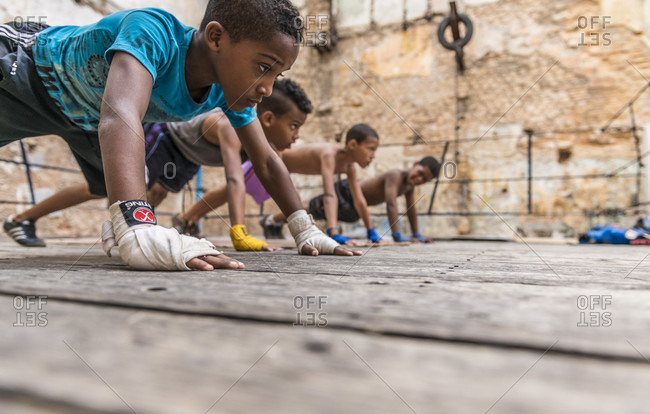 Old Havana, La Habana, Cuba - April 24, 2014: Four Cuban boys exercising on the ring of the Project Cuba Boxeo, an aid project from Malaika Aid for Children, the creation of Samuel 'Sammy' Fabbri. The organization brings boxing to Cuban children from 8-21 years of age. The boxing ring sits between a group of crumbling buildings between Calle San Jose and Calle Aguila, in Old Havana or Habana Vieja, La Havana, Cuba