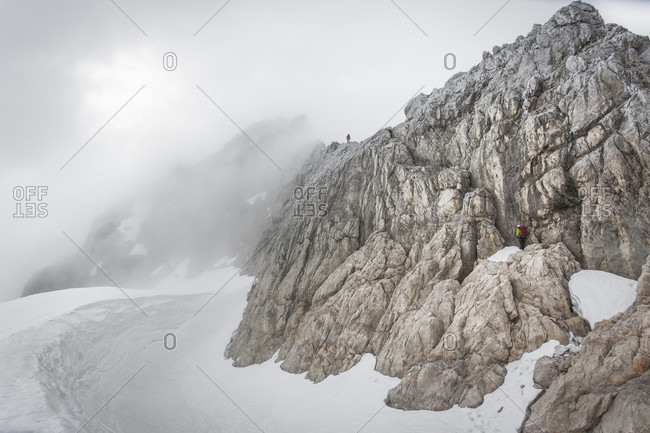 Dachstein, Styria, Austria - June 18, 2015: Professional highline athlete Reinhard Kleindl and his crew on a special alpine highline project in the Austrian alps. This project is set almost at 3000 meters above see level. The project involves a difficult climbing access as well as special rigging skills