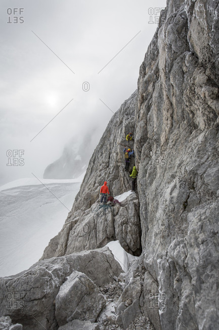 Dachstein, Styria, Austria - June 18, 2015: Professional highline athlete Reinhard Kleindl and his crew on a special alpine highline project in the Austrian alps. This project is set almost at 3000 meters above see level. The project involves a difficult climbing access as well as special rigging skills