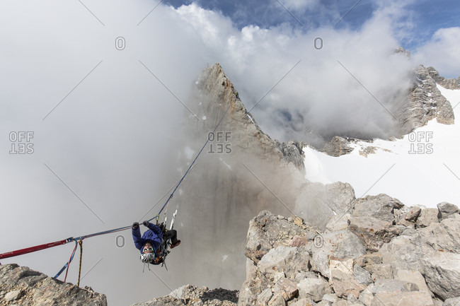 Dachstein, Styria, Austria - June 30, 2015: Professional highline athlete Reinhard Kleindl and his crew on a special alpine highline project in the Austrian alps. This project is set almost at 3000 meters above see level. The project involves a difficult climbing access as well as special rigging skills