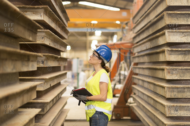 Woman looking at material in factory hall