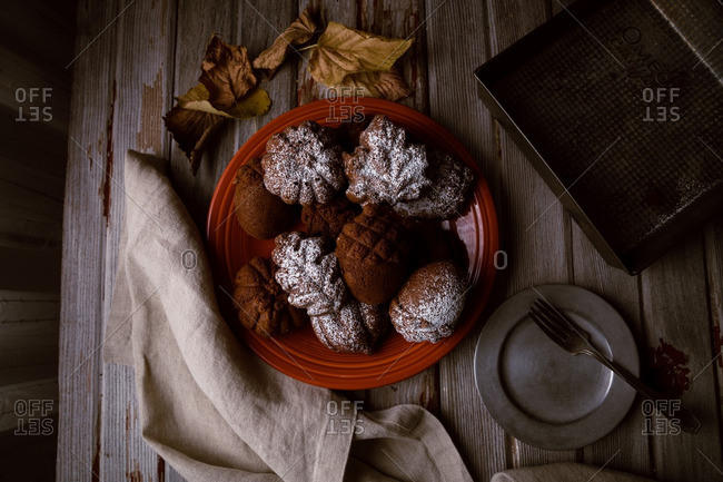 Plate of autumn cakes arranged on table with leaves and linen napkin