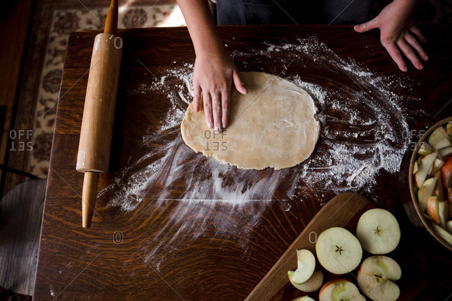 Pressing out pie crust dough for apple pie