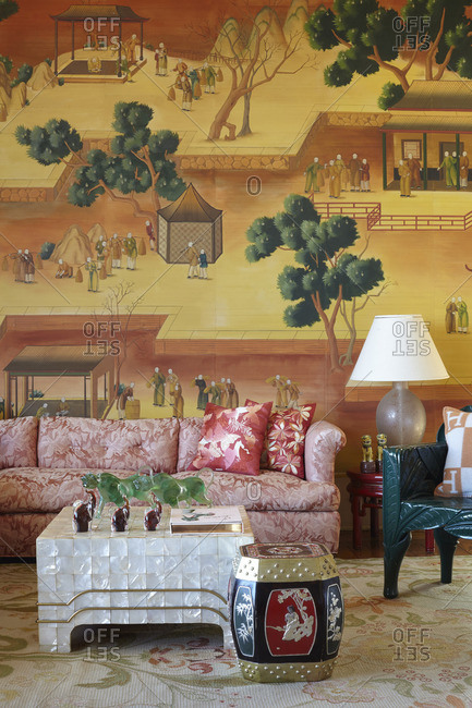 October 7, 2014: Floral red sofa in a room with an Asian wall mural