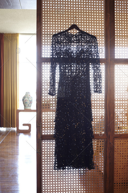 Black lace dress hanging on a wall screen