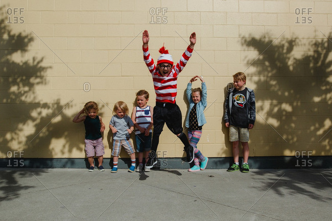 Children playing together outside in front of a wall
