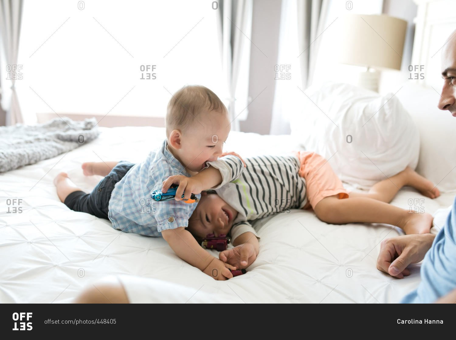 Brothers wrestling together on a bed