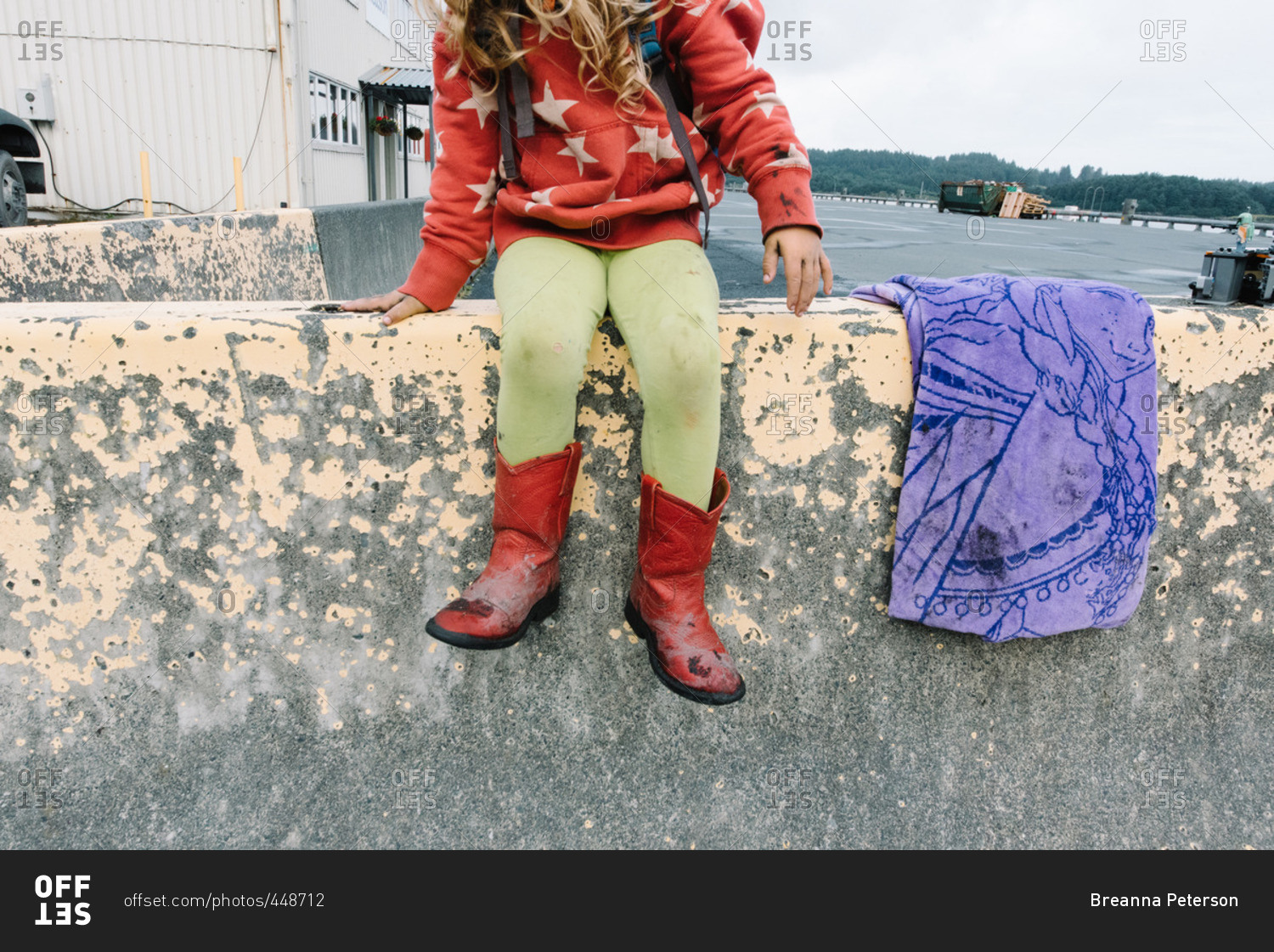 Girl on concrete ledge in port