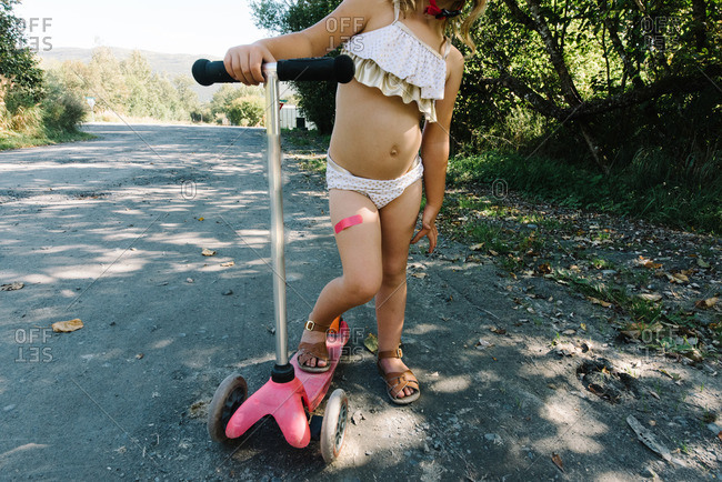 Girl with scooter on a country road