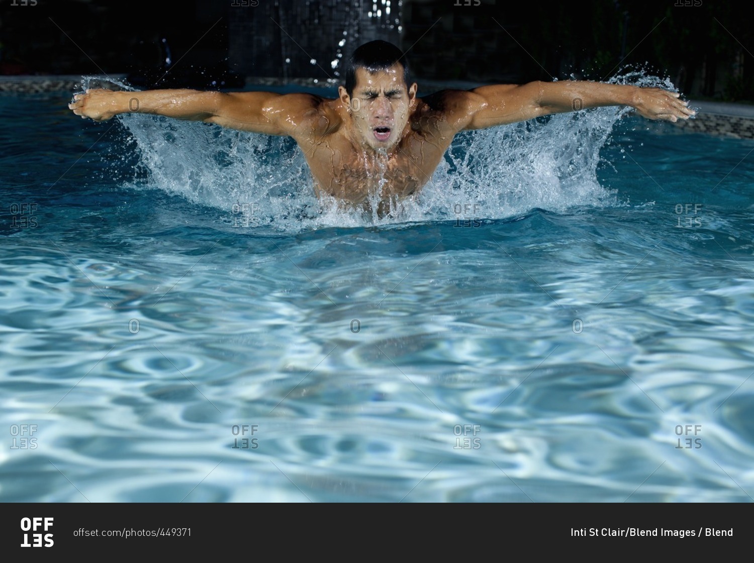 Pacific Islander man swimming in swimming pool