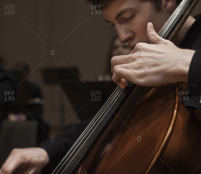 Man playing cello in orchestra