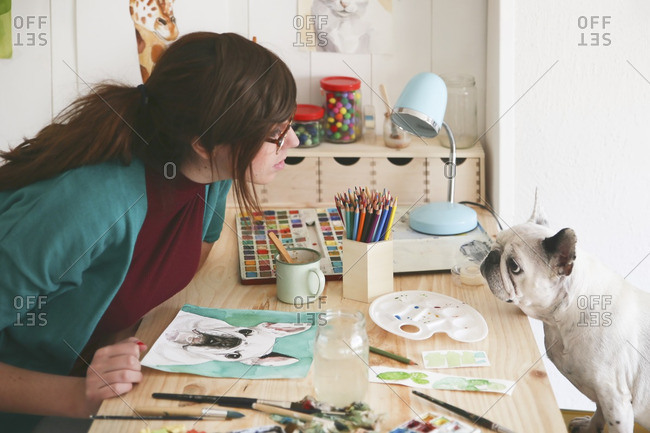 Artist watching French bulldog in her studio