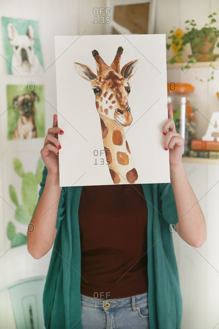 Artist hiding behind aquarelle of a giraffe