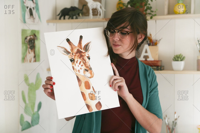 Portrait of artist showing her aquarelle of a giraffe