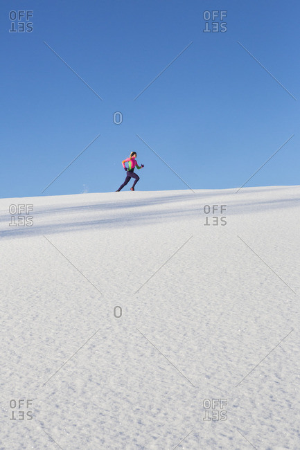 Sweden, Medelpad, Sundsvall, Woman running on snowy day