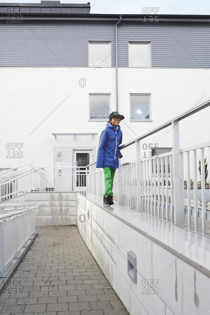 Sweden, Vastra Gotaland, Grimmered, Boy walking on top of wall by railing