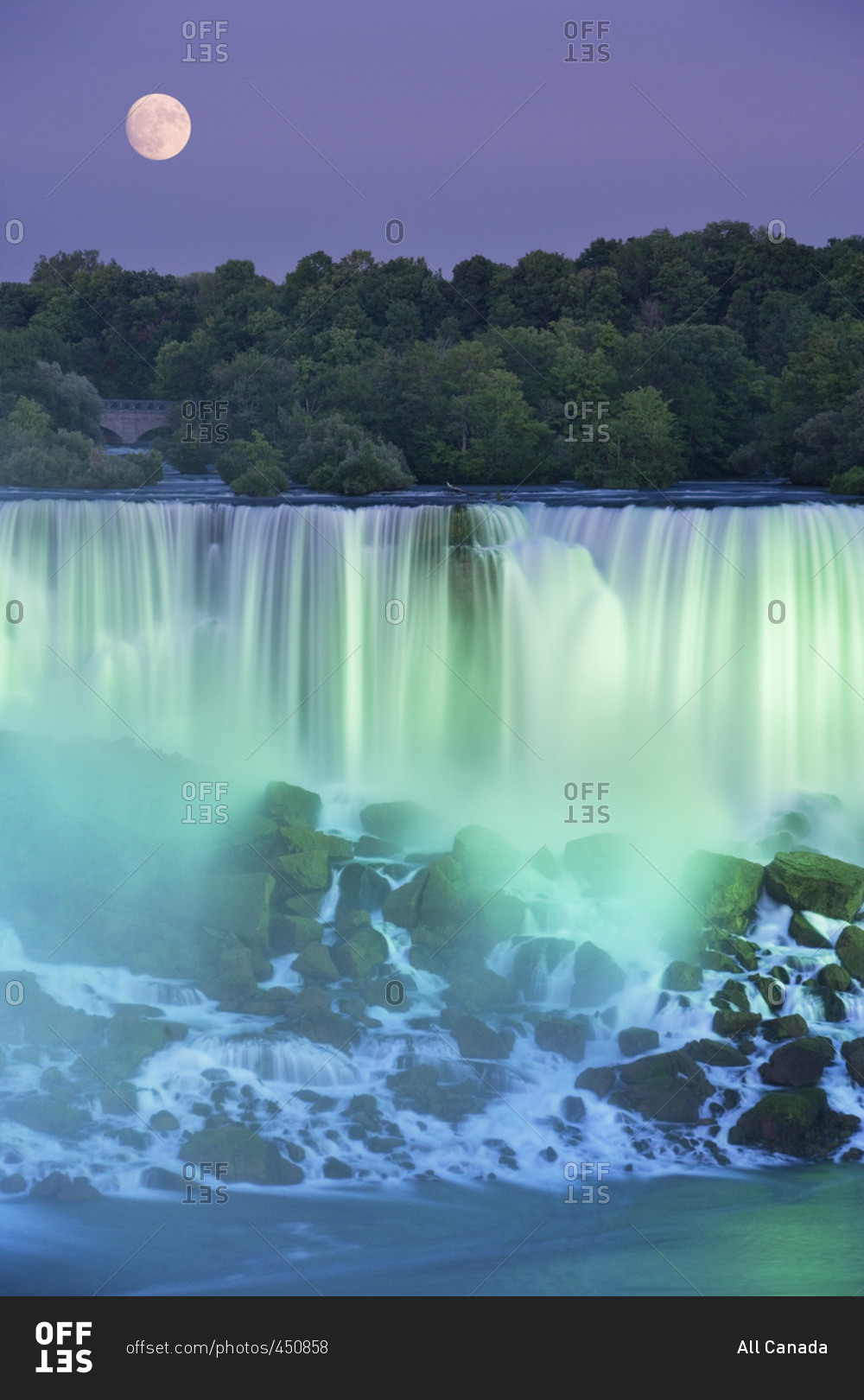 The American Falls with Full moon at dusk lit with lights photographed from Niagara Falls, Ontario, Canada