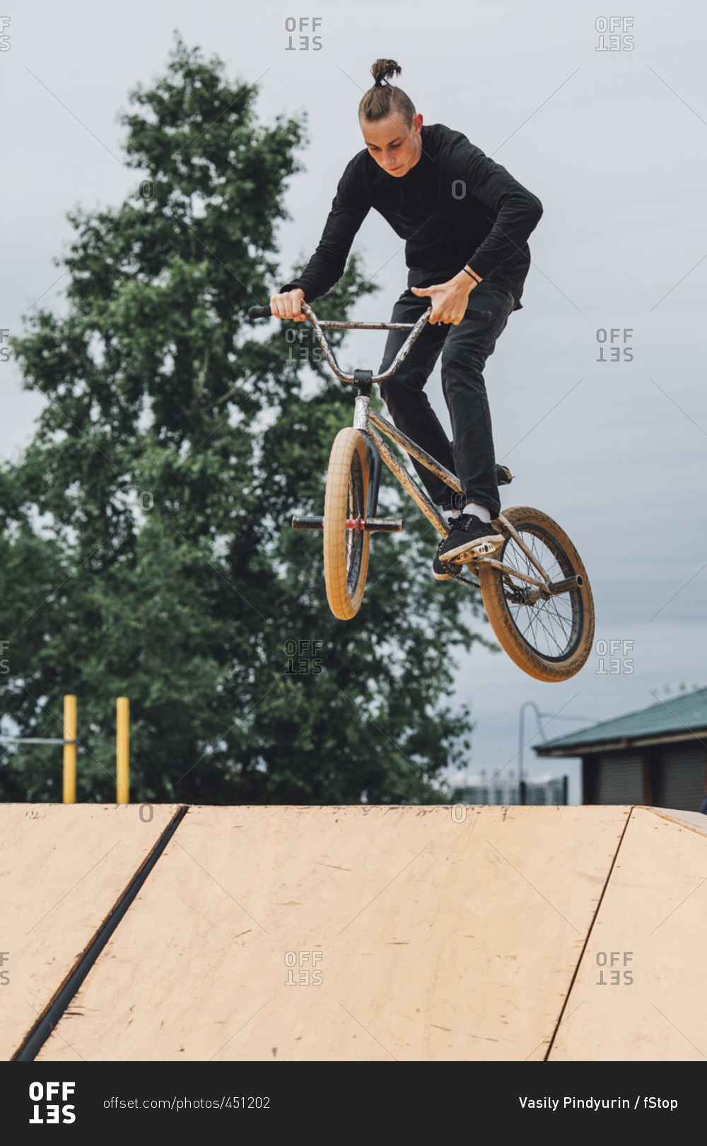 Low angle view of teenager performing stunt on ramp at skateboard park