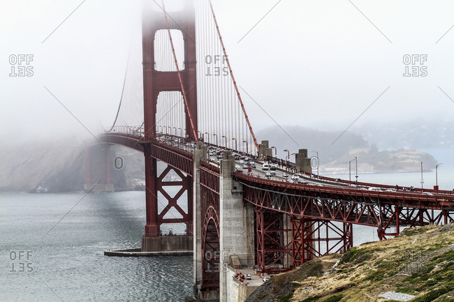 View of Golden Gate Bridge over bay of water during foggy weather