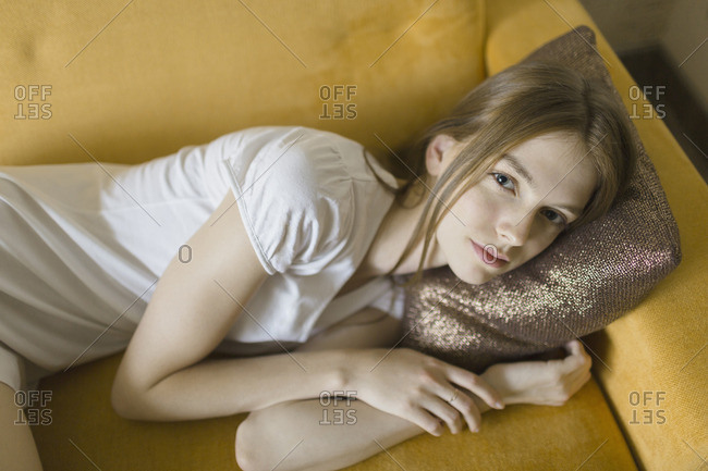 High angle portrait of young woman resting on sofa at home