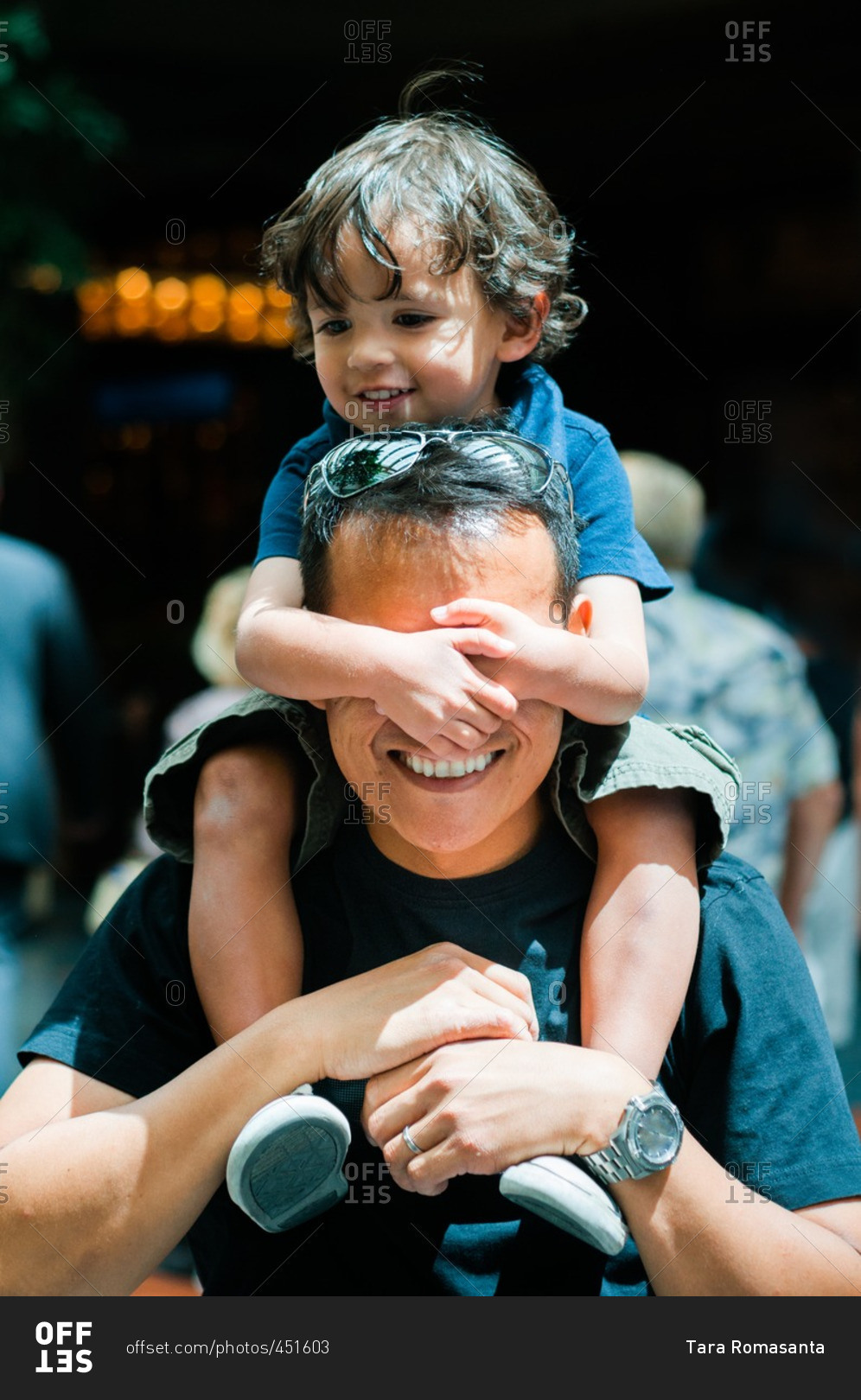 Boy covering man\'s eyes while on shoulders