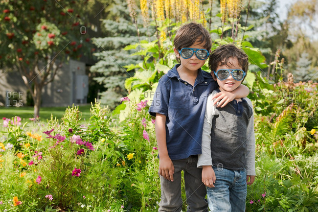 Two boys with sunglasses on outside