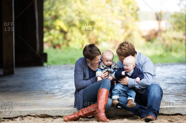 Women holding their twin babies outdoors