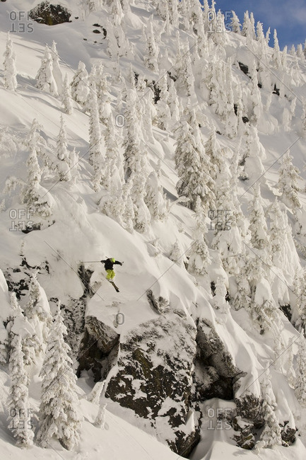 A male freeskier airing a cliff in the Revelstoke  Resort Backcountry, BC
