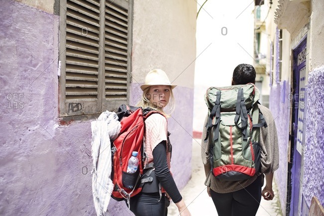 Backpackers walking through alley