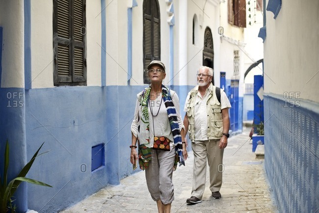 Senior couple walking through blue alley