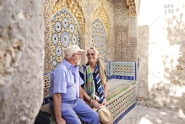 Senior couple resting on tiled bench