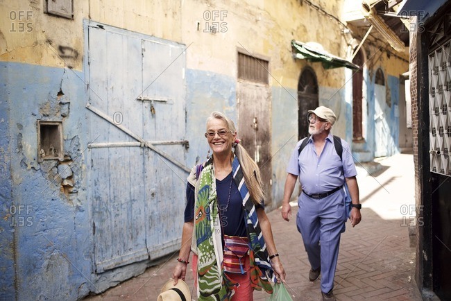 Senior man and woman exploring narrow alley