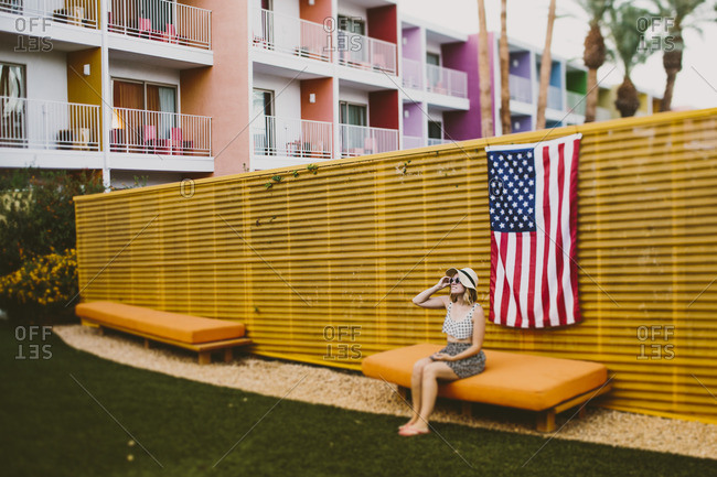Woman in front of American flag at a colorful hotel